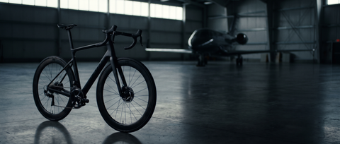 Black road bike in a private jet hangar
