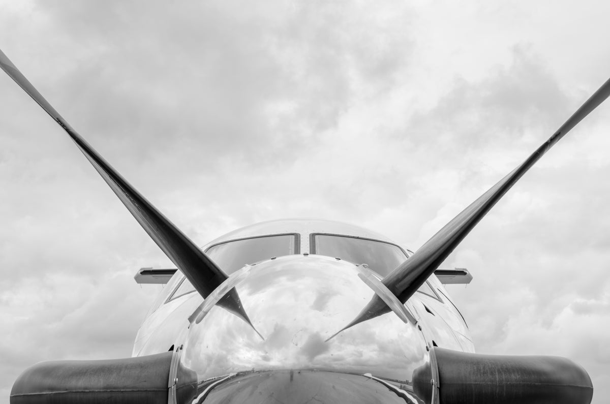 Polished turboprop nose and propeller blades against the clouds